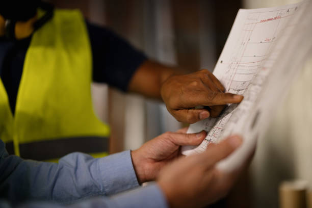 istock Close-Up of Construction Workers Reviewing Building Plans on Site 2189260238