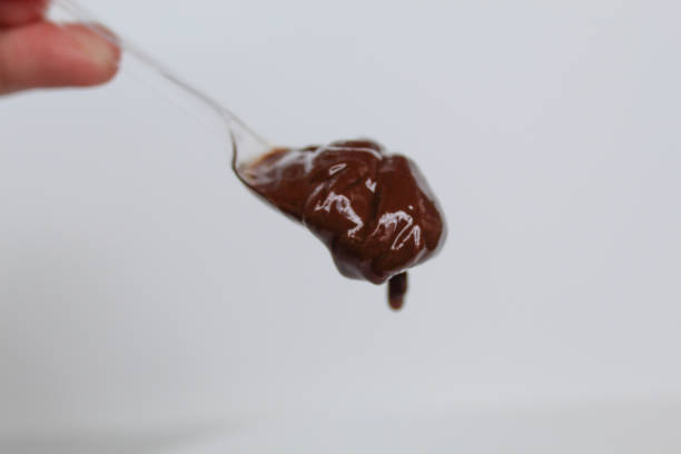 istock One spoon of melted dark chocolate, or chocolate spread, isolated on white background 2189260331