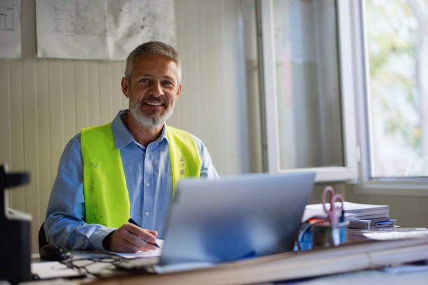 istock Confident Construction Worker in Safety Vest at Office Desk 2189260332