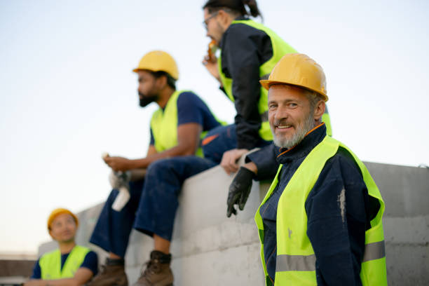 Smiling Construction Workers In Safety Gear Taking A Break On Site
