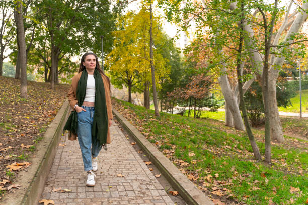 istock Woman walking through a park in autumn. 2189261442