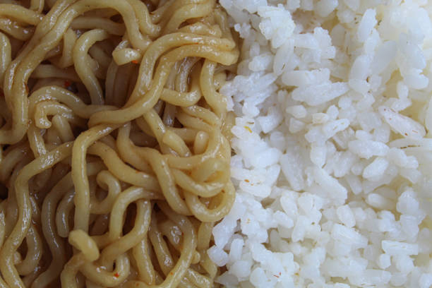 Fried instant noodles, side by side with white rice, flat lay or top view
