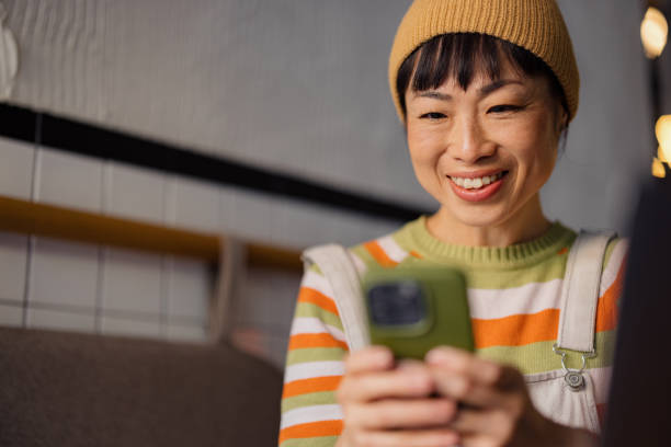 istock Smiling woman Using Smartphone in Cozy Coffee Shop Setting 2189266988