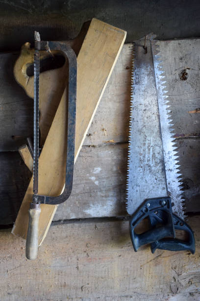istock Old various hand saws and a plane for woodworking hang on the wall in the barn. Vintage tools 2189267027