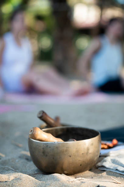 istock Tibetan singing bowl on sand with blurred people practicing yoga in sri lanka 2189267918