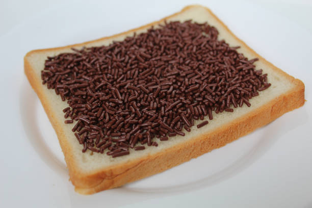 istock One slice of white square bread, with chocolate sprinkles spread, on white plate, isolated on white background 2189268319