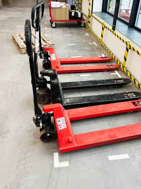 istock Industrial warehouse with red pallet jacks and loaded carts in storage area 2189269567