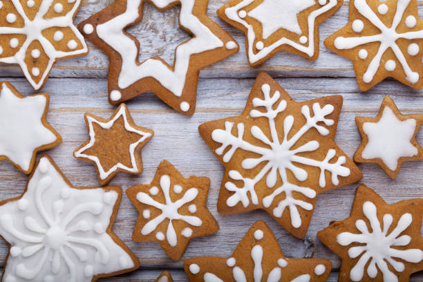 istock Gingerbread Christmas gingerbread cookies star shape with white icing full frame on brown wooden table. 2189270244