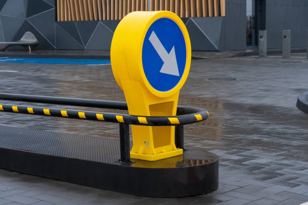 istock A bright yellow directional sign with an arrow points left at a contemporary city intersection. The wet pavement reflects the surroundings, highlighting the urban design and rainy weather 2189270404