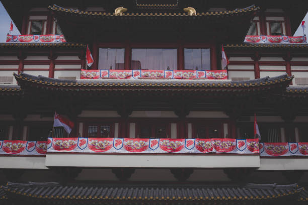 Singapore. January 2020.  The faithful pray with the monk in front of the Buddha statue in Buddha Tooth Relic Temple