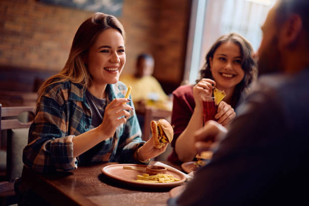 istock Happy woman talking to her friends while eating in a pub. 2189273698