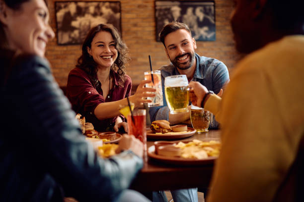 istock Multiracial group of friends toasting while eating in a bar. 2189273730