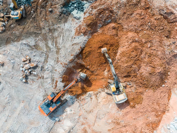 istock Large tracked excavator with hydraulic hammer breaks asphalt at a construction site 2189285225