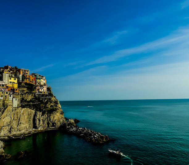 A beautiful blue ocean with a small boat in the water. The sky is clear and the sun is shining