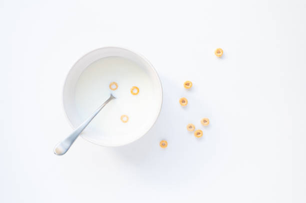 Bowl of milk with three cheerios cereal on white background. in Kingston, Ontario, Canada