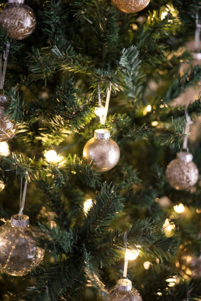 istock Gold shimmering ornaments hanging on a christmas tree 2189304347