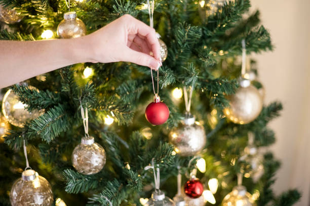 istock Woman hanging a red ornament on the christmas tree 2189304379