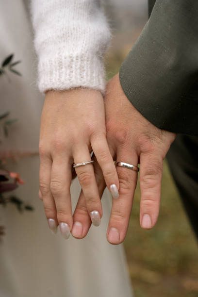 istock Newlywed couple holding hands wearing wedding rings 2189305377