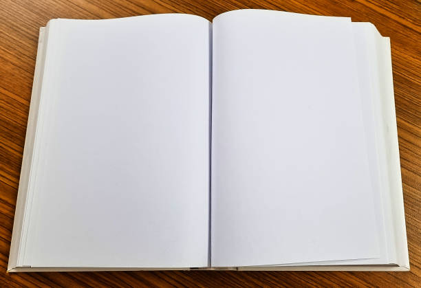 istock Open blank book on wooden table ready for notes or ideas in an office or study environment 2189308411