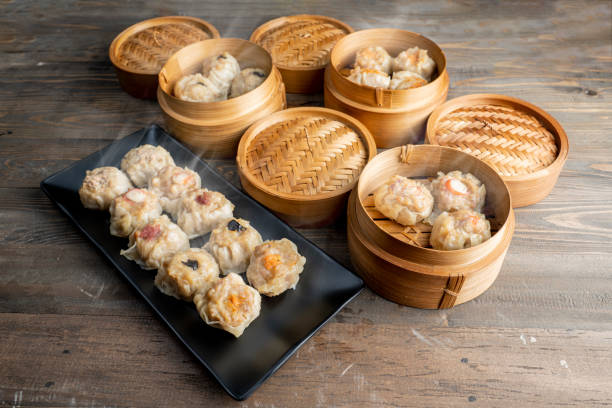 istock Assorted chinese dim sum dumpling on the plate with bamboo wooden basket bowl on wooden table 2189309033