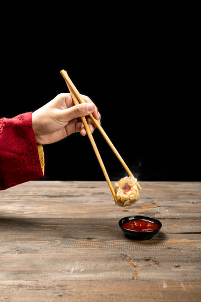 istock Chinese person with chopstick eating chinese dim sum dumpling with sauce 2189309613