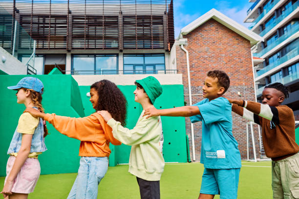Kids in green hoodie school uniform near white wall background, copy space