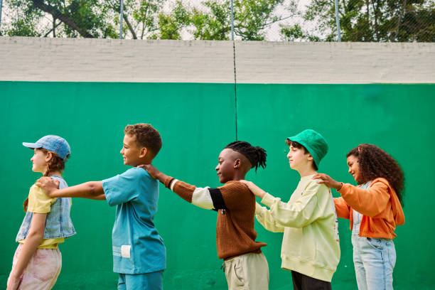 Elementary school students forming a line and playing together in the schoolyard, demonstrating teamwork and diversity