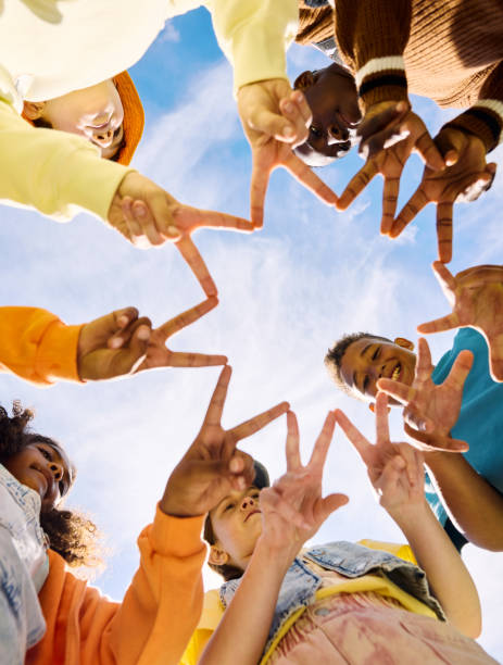 istock Schoolkids joining hands forming star shape with fingers: 2189309899