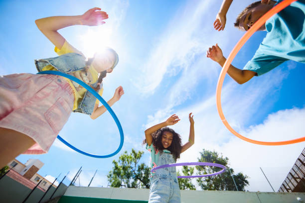 istock Happy multiethnic schoolkids playing with hula hoops outdoors 2189309910