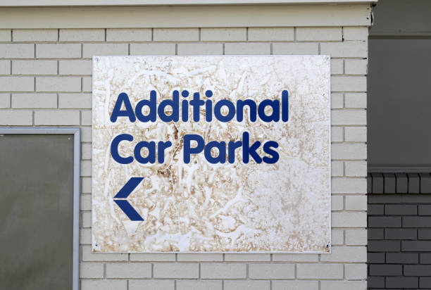 istock Old and weathered Additional Car Parks sign attached to a brick wall 2189314180