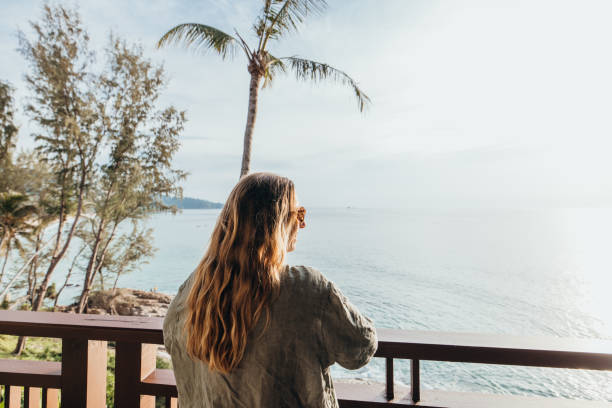 istock Woman Relaxing on Balcony Overlooking Ocean at Sunset 2189314418