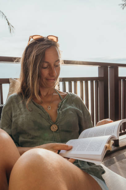 istock Woman Relaxing on Balcony Reading a Book 2189314495