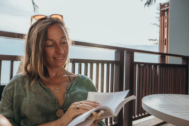 istock Woman Relaxing on Balcony Reading a Book 2189314611