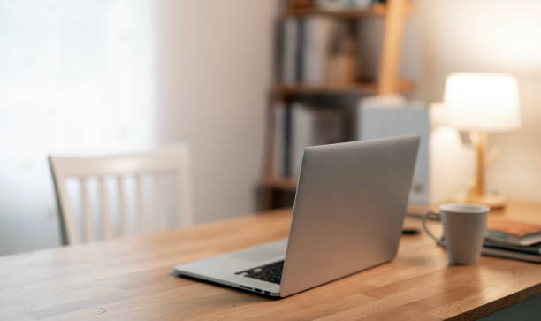 istock Close up view of simple workspace with laptop, notebooks, on wooden table with blurred office room background 2189321162