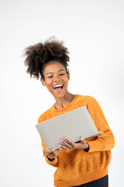 istock Cheerful young black woman holding laptop computer standing on white background 2189322022