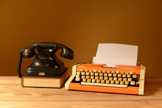 istock Still life, old telephone, old typewriter, paper and book 2189323037