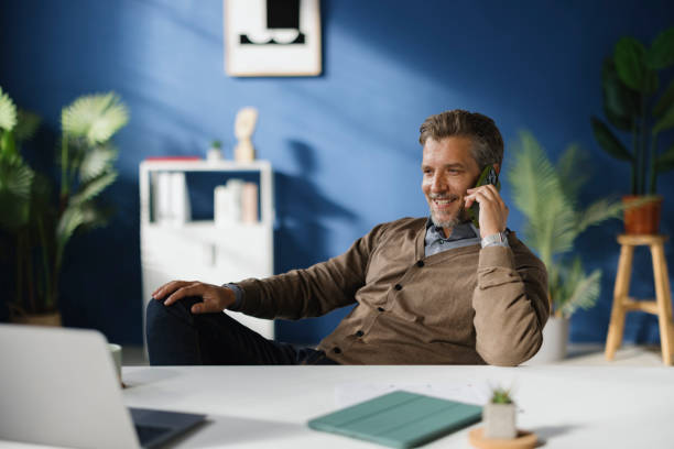 istock Happy businessman talking on smart phone while working in the office. 2189327485