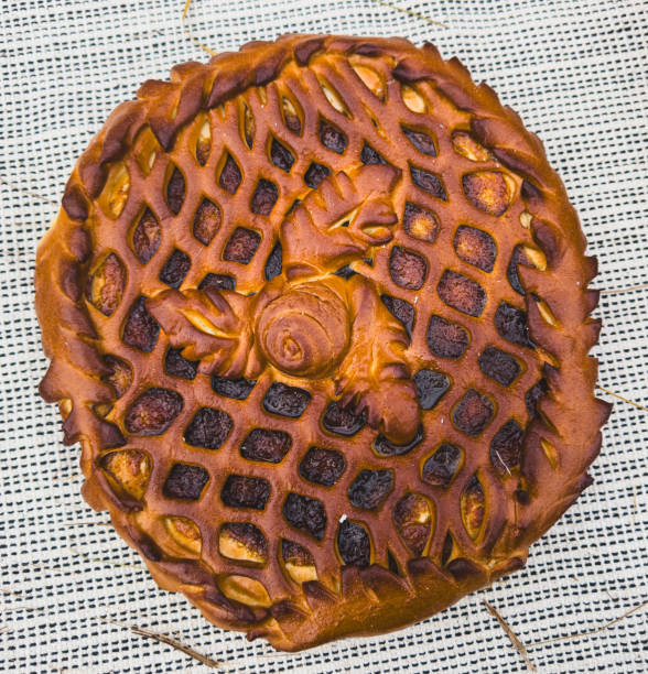 A baked pastry with a lattice design on top. The pastry is brown and has a golden crust