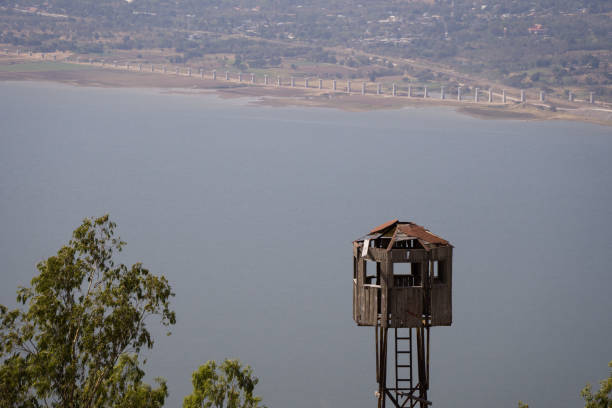 istock Derelict fire tower used for fire spotting and forest fire control with new road building in background 2189332476