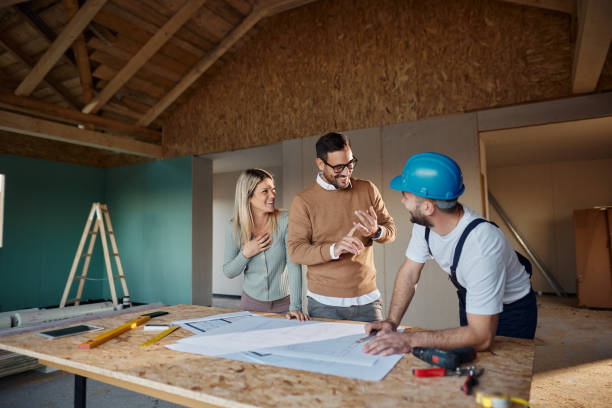istock Happy couple talking to manual worker at construction site. 2189333067