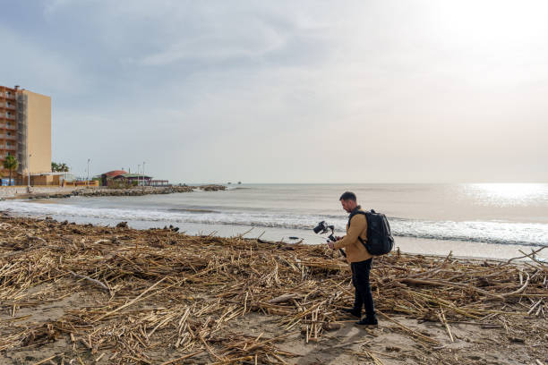 istock Videographer captures footage of storm aftermath, showcasing debris on the beach 2189335125