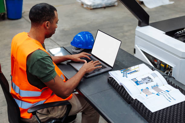 istock Industrial engineer working on laptop with empty screen in factory 2189337542