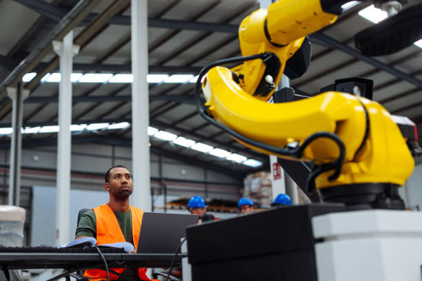 istock Supervisor controlling robotic arm with laptop in factory 2189337548