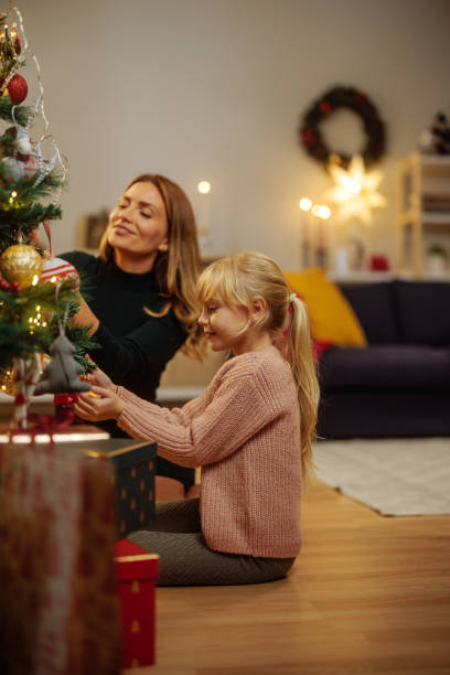 istock Mother and her little daughter decorating a Christmas tree 2189338043