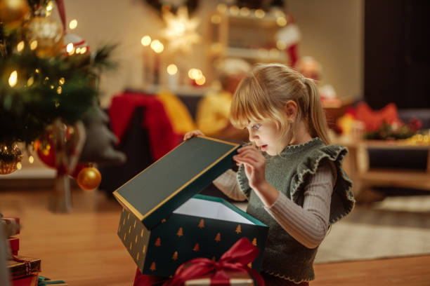 istock Little girl opening a mysterious Christmas present 2189338147