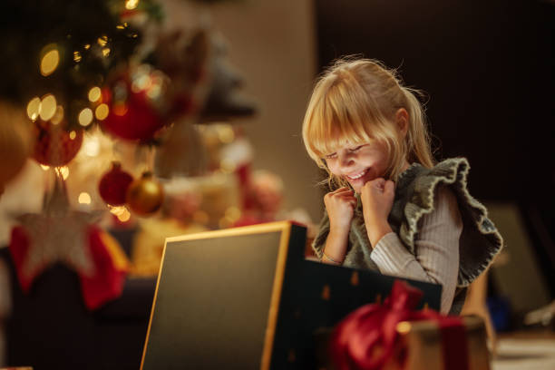 Excited girl opening a glowing Christmas present