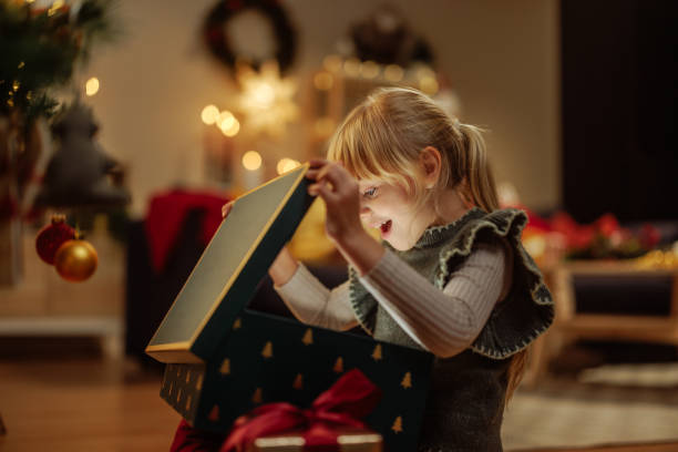 istock Surprised girl opening a glowing Christmas present 2189338200