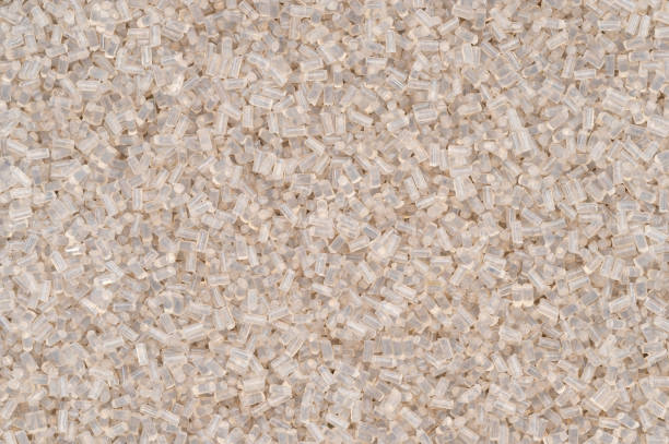 A macro photograph of recycled polyethylene terephthalate (PET) granulate showcasing their translucent texture. These granules are widely used in sustainable manufacturing and eco-friendly product development.