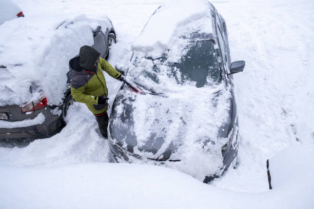 istock Person Clearing Snow from Car in Winter Landscape 2189339964