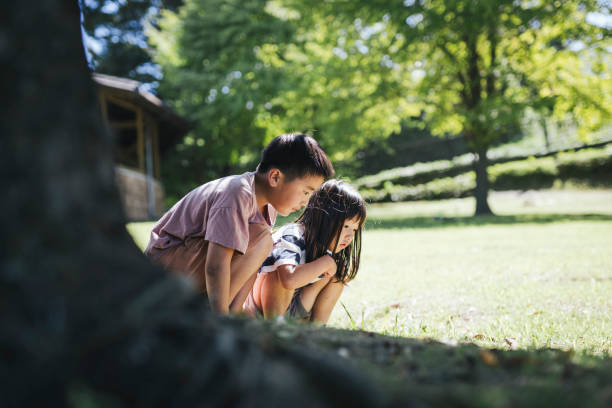 Asian brother and sister playing in the forest.
